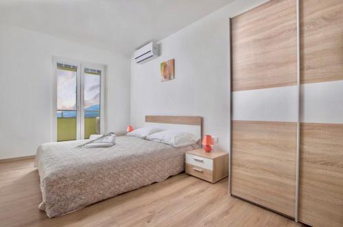 een slaapkamer met een bed en een grote kast bij Villa Alternus-apartman Dora in Ičići
