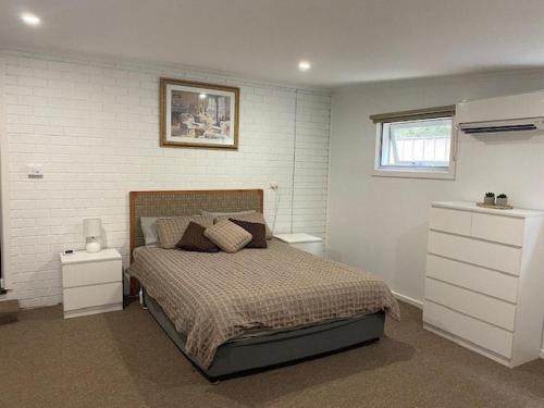 a bedroom with a bed and a white brick wall at The River Rest in Nagambie in Nagambie