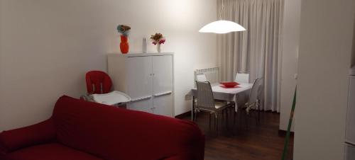 a living room with a red couch and a table at L'OLIVO appartamento turistico in Lucignano
