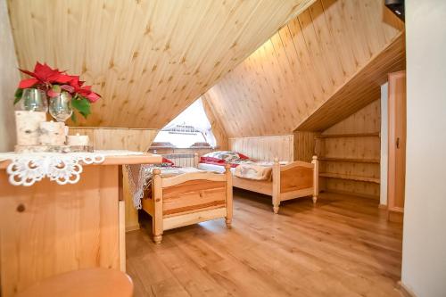 een zolderkamer met een bed en een tafel bij Willa Klimek Biały Dunajec in Zakopane
