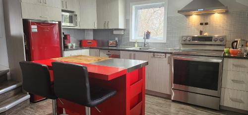 a kitchen with a red island in the middle at Maison 3 chambres Inspiration in Amos