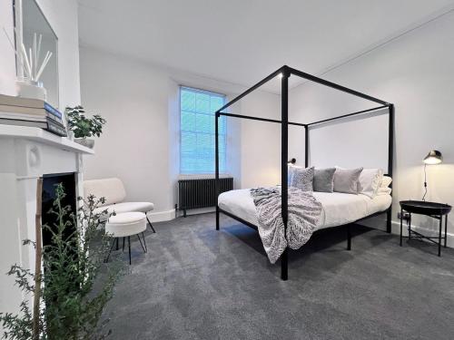 a bedroom with a canopy bed and a fireplace at Exquisite Period House, Heart of Exeter, Parking in Exeter