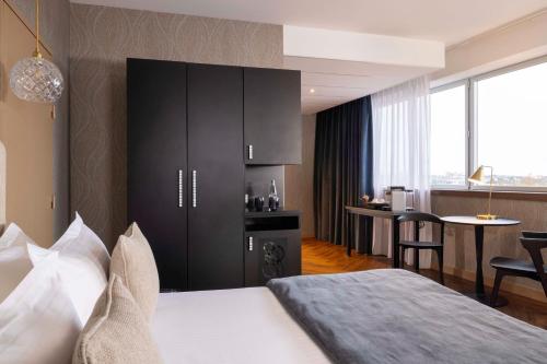 a hotel room with a bed and a table with chairs at Best Western Plus Hôtel Isidore in Saint-Jacques-de-la-Lande
