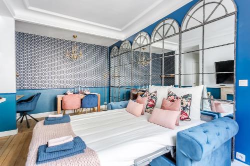 - une chambre avec des murs bleus et un lit avec des oreillers roses dans l'établissement V3 Vibrant Stay Luxurious Stay Steps from Trocadéro, à Paris