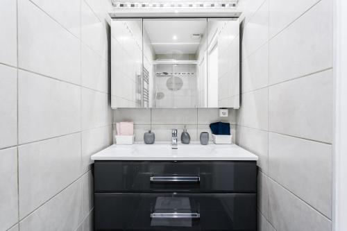 une salle de bain avec un lavabo et un miroir dans l'établissement V3 Vibrant Stay Luxurious Stay Steps from Trocadéro, à Paris