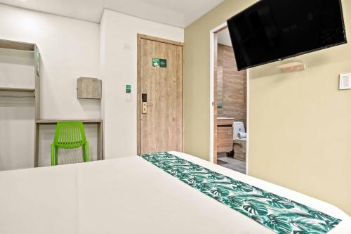 a bedroom with a bed and a flat screen tv at Hotel Eco Suite in Cali