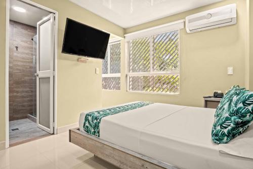 a bedroom with a bed and a flat screen tv at Hotel Eco Suite in Cali