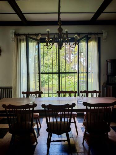 a dining room with a table and chairs and a large window at Estancia Loma Pampa in Azul