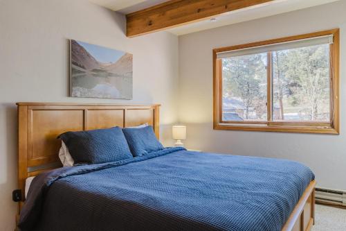a bedroom with a blue bed and a window at PS-1000 Cloud Cap in Pagosa Springs