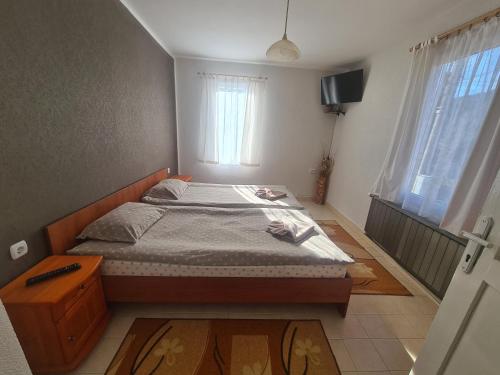 a bedroom with a bed and a television in it at Мальовица - къща за гости in Dospey Makhla
