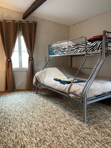 a bedroom with two bunk beds and a window at Grand Gîte à 25 minutes du Puy Du Fou in Montournais