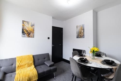 a living room with a couch and a table at Open Mind Property - 2 BR, 4 Beds & 9 Guests in Portsmouth