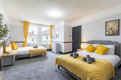 a hotel room with two beds and yellow curtains at Open Mind Property - 2 BR, 4 Beds & 9 Guests in Portsmouth