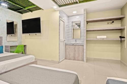 a hotel room with two beds and a television at Hotel Eco Suite in Cali