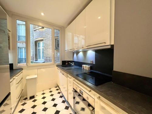 - une cuisine avec des placards blancs et un sol en damier dans l'établissement À Bastille - Le Spacieux - 22MC, à Paris