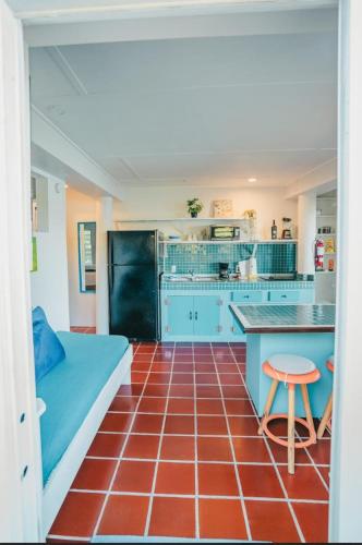 a kitchen with blue cabinets and a red tile floor at Ocean Front Villa 2 in Culebra
