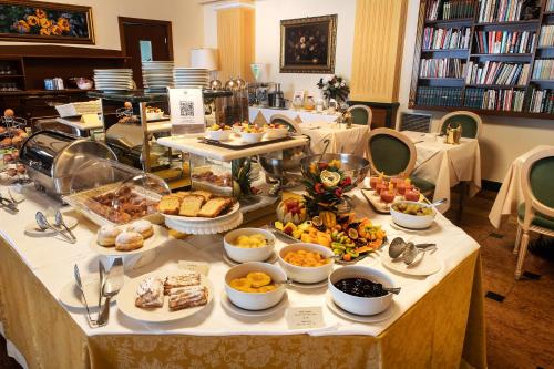 a buffet of food on a table in a library at Santa Barbara Hotel in San Donato Milanese