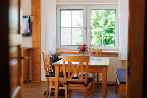 a dining room with a table and chairs and a window at Ferienhof Sonnengarten in Gunzenhausen