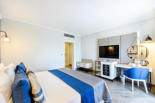 a bedroom with a bed and a desk and a television at Club Marco Polo - Premium All Inclusive in Kemer