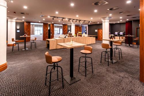 a large room with chairs and tables and a bar at Pentahotel Leipzig in Leipzig