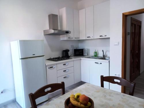 a kitchen with a table with a bowl of fruit on it at Casa Vacanze Nuvola in Pietralunga