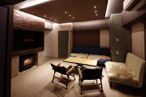 a living room with a table and a fireplace at MolinHotels206-中山峠スキー場まで車で30分-K-bed1 & S-bed3 in Jozankei