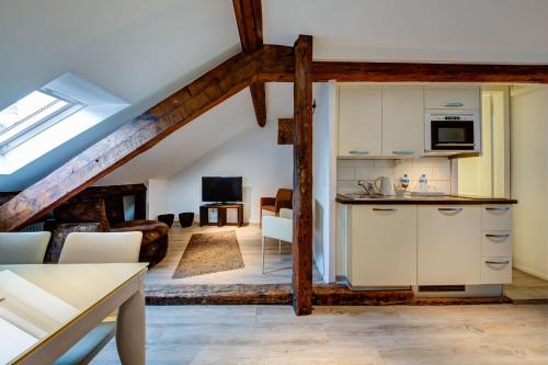 a kitchen with a refrigerator, stove, sink and cabinets at Hôtel du Raisin in Lausanne