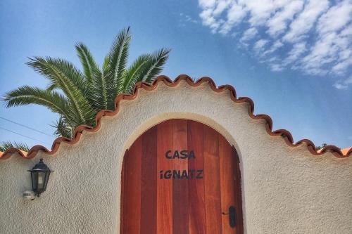 a building with a wooden door and a palm tree at Casa Ignatz 5 Bed Luxury Villa with Private Pool in Jávea