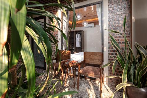 a room with a table and chairs and plants at Trang An Aroma Ecolodge Ninh Binh in Ninh Binh