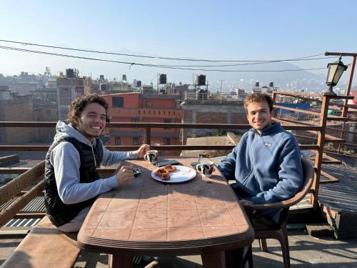 two people sitting at a table with a plate of food at Bhaktapur Homestay in Bhaktapur