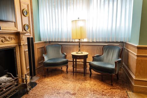 a room with two chairs and a table and a lamp at Santa Barbara Hotel in San Donato Milanese