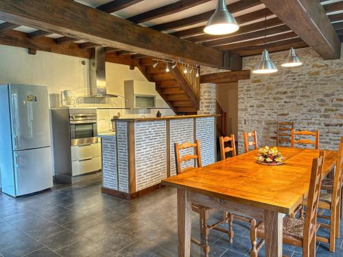 une cuisine avec une table en bois et un réfrigérateur dans l'établissement Gite St Loup, à Boyer