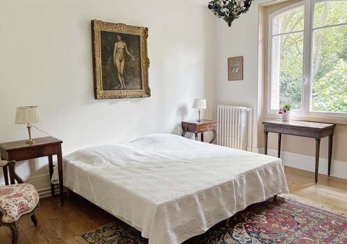 une chambre avec un lit et un tableau au mur dans l'établissement L'Auberge 91530, à Le Val-Saint-Germain
