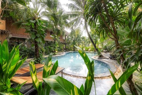 a swimming pool in a resort with palm trees at Trang An Aroma Ecolodge Ninh Binh in Ninh Binh