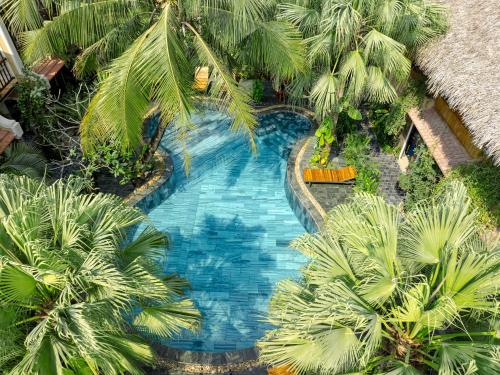 an overhead view of a swimming pool with palm trees at Trang An Aroma Ecolodge Ninh Binh in Ninh Binh