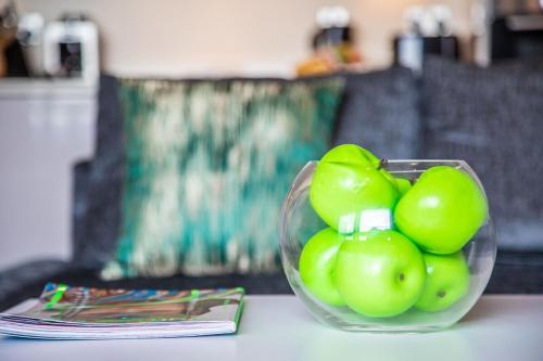 a glass bowl of green fruit sitting on a table at Lovely Skyline Views 2 Bedroom Apartment in Ashford in Ashford