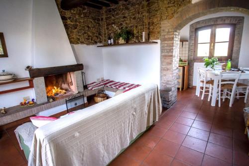 a living room with a fireplace and a dining room with a table at Tenuta di Paganico - I Roggeti in Paganico