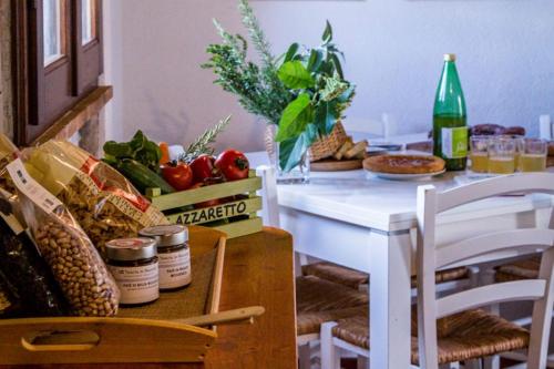 a dining room table with a white table with vegetables on it at Tenuta di Paganico - I Roggeti in Paganico