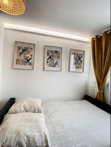 - une chambre avec un lit et trois photos sur le mur dans l'établissement L'Haneri - Center, WIFI - Comfort et Modern Style, à Amiens