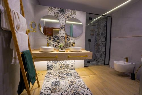 a bathroom with two sinks and a mirror at Al Marmoom Oasis Luxury Experiential Desert Resort in Dubai