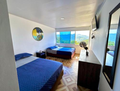 a bedroom with a blue bed and a window at Hotel Zipa Villeta - Sede Campestre in Villeta