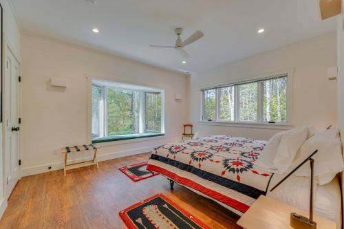a bedroom with a bed and two windows at Riverfront Hideaway in Keene Walk to Town! in Keene