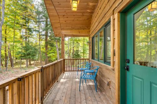 a wooden porch with a blue door and a chair at Riverfront Hideaway in Keene Walk to Town! in Keene