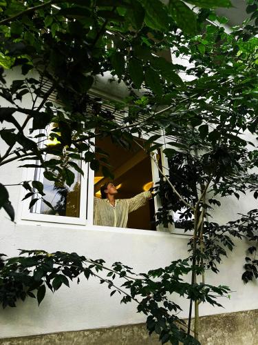 a woman is looking out of a window at Pretty Villa in Gelioya