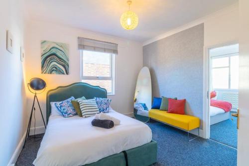 a bedroom with a bed and a surfboard on the wall at Rayleigh Retreat-Spacious Family 3 Bed Apartment in Rayleigh