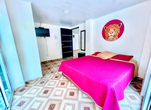 a bedroom with a pink bed in a room at Hotel Zipa Villeta - Sede Campestre in Villeta