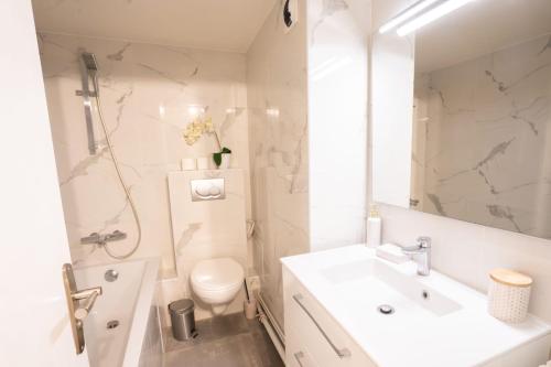 une salle de bain blanche avec un lavabo et des toilettes dans l'établissement Studio parisien face metro - Paris 9 - 2p - FLAT-GUEST, à Paris