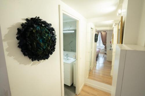 La salle de bains est pourvue d'un miroir et d'une couronne sur le mur. dans l'établissement Studio parisien face metro - Paris 9 - 2p - FLAT-GUEST, à Paris