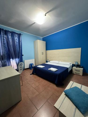 a blue bedroom with a bed and a blue wall at Guest House GeMar in Lauria