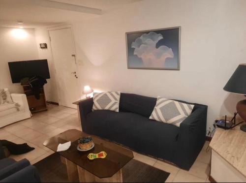 a living room with a black couch and a table at Punta Del Este, Península Santos Dumont, 2 dormitorios, 2 baños, 5 personas in Punta del Este
